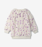 A long-sleeve fuzzy knit sweater in cream with an all-over sequined floral pattern in shades of purple and pink, displayed flat against a light gray background.