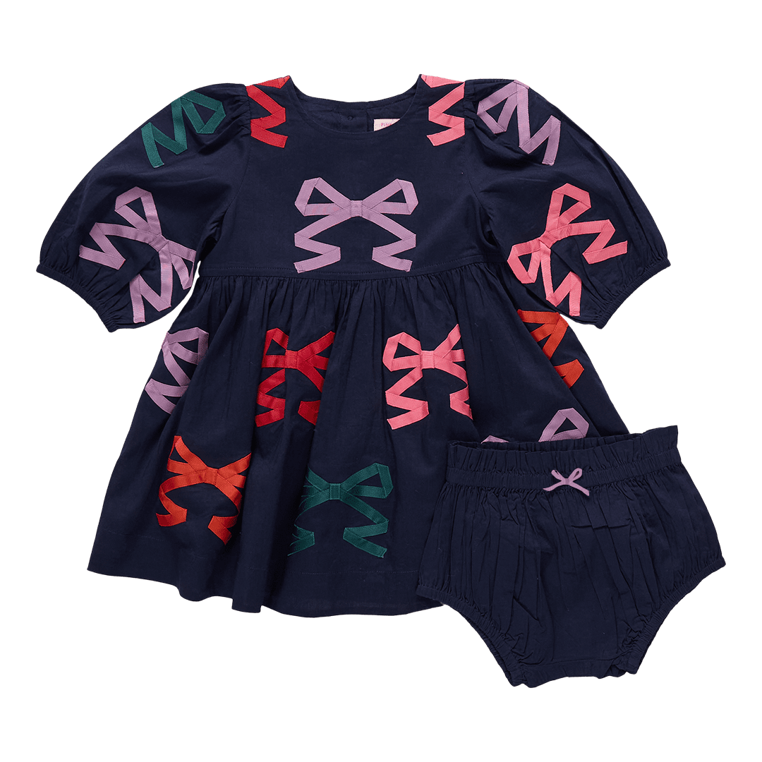 Navy blue dress with colorful bow patterns and matching bloomers on a transparent background