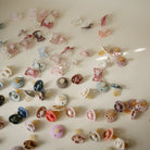 Collection of various baby accessories including pacifiers and hair clips on a light background