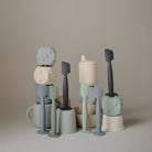 Set of colorful ceramic kitchen utensils on a neutral background