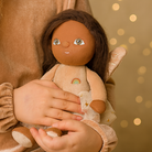 Child holding a doll with a soft focus gold background
