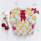 Baby romper with apple pattern and red bows on a white background