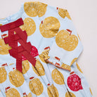 Children's dress with yellow apple pattern and red accents on a light blue background