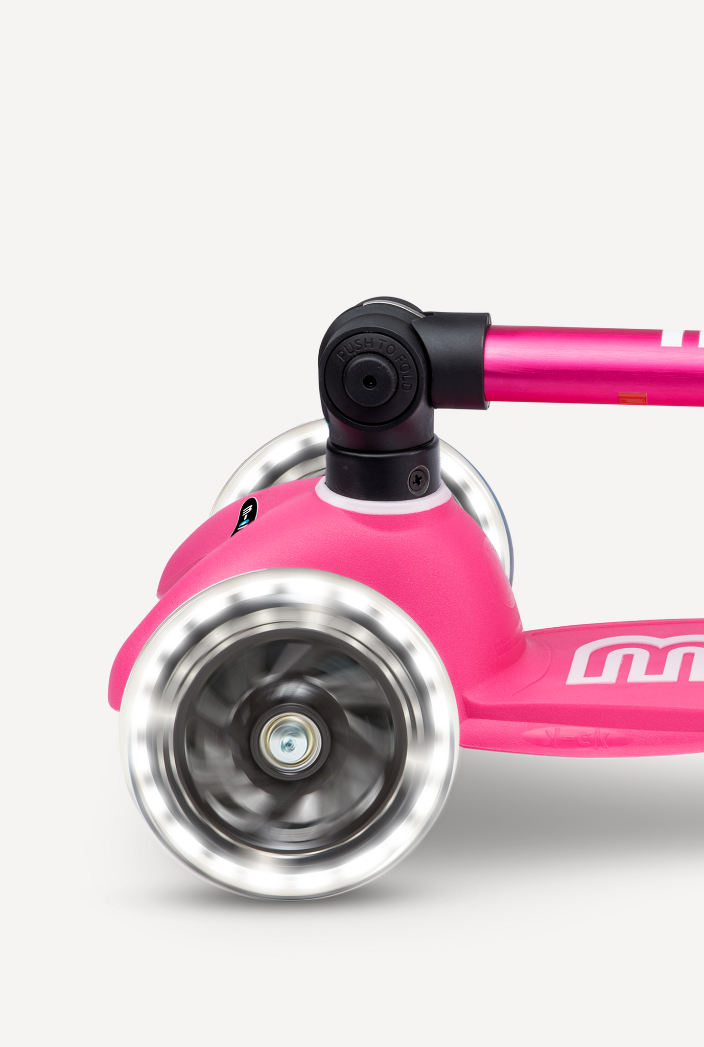 Close-up of a pink scooter with a silver wheel on a white background