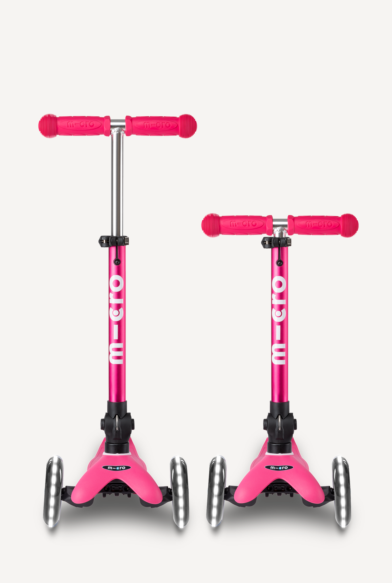 Two pink Micro scooters on a white background