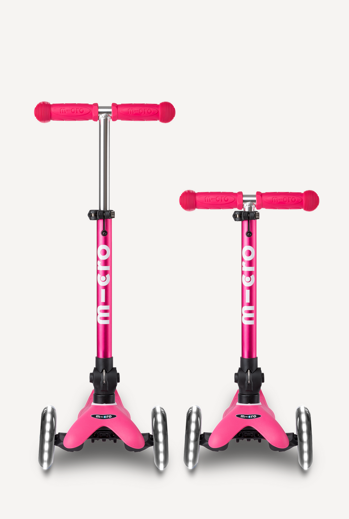 Two pink Micro scooters on a white background