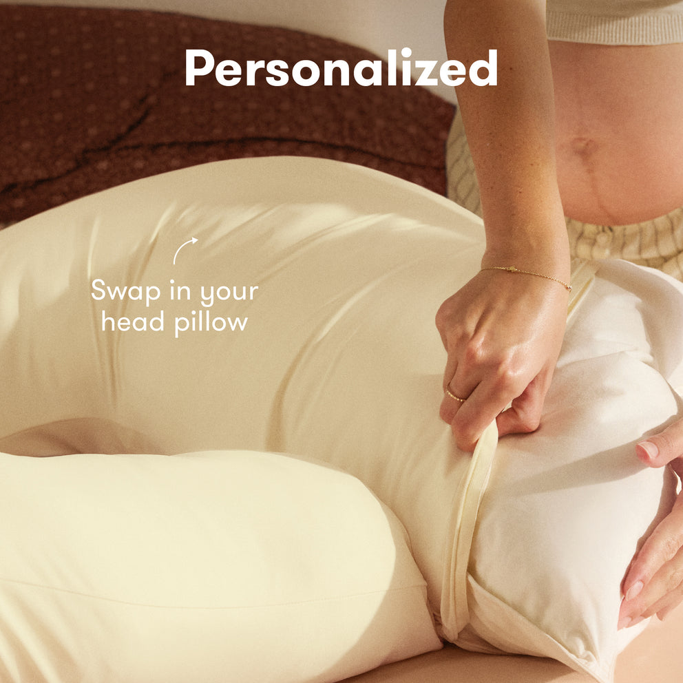Person adjusting a beige pillow with text indicating it can be personalized by swapping in a head pillow.
