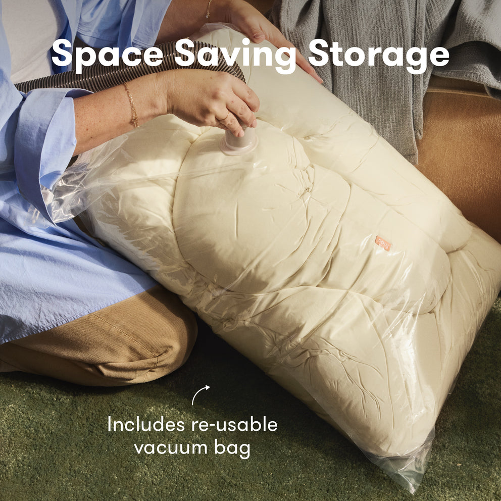 Person using a re-usable vacuum bag to compress a large item, with text 'Space Saving Storage' and 'Includes re-usable vacuum bag'.
