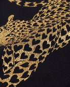 Close-up of a leopard pattern with black hearts on a dark background