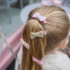 Child's hair with decorative hair clips in a blurred indoor setting