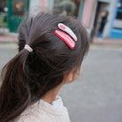 Close-up of a person's hair with decorative hair clips in an urban setting