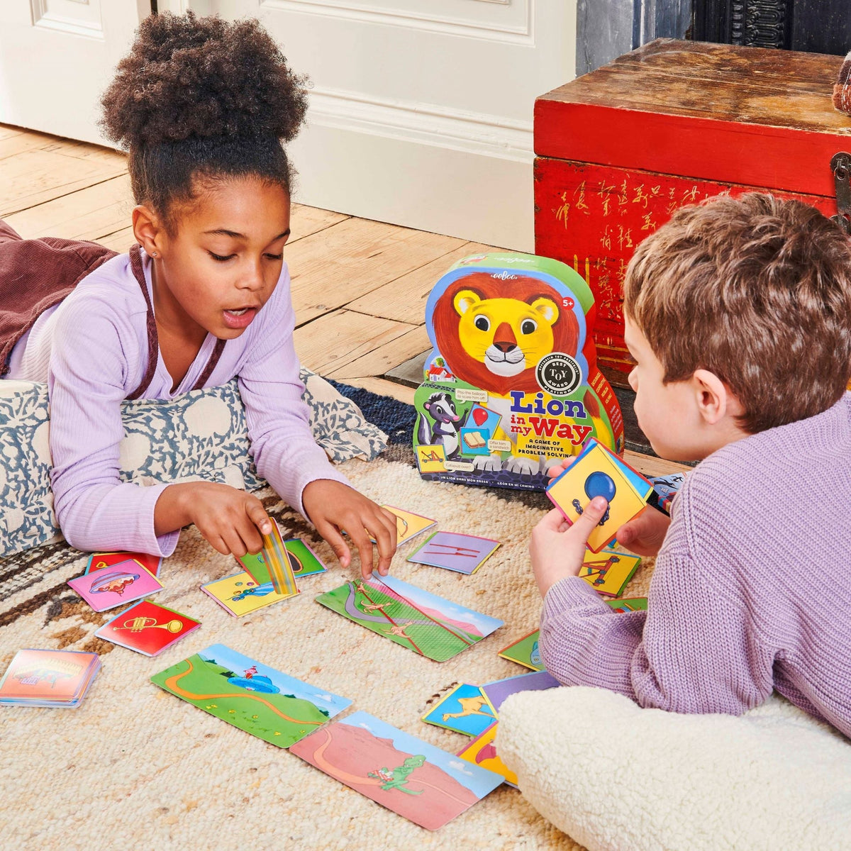 Two children playing with educational cards on the floor.
