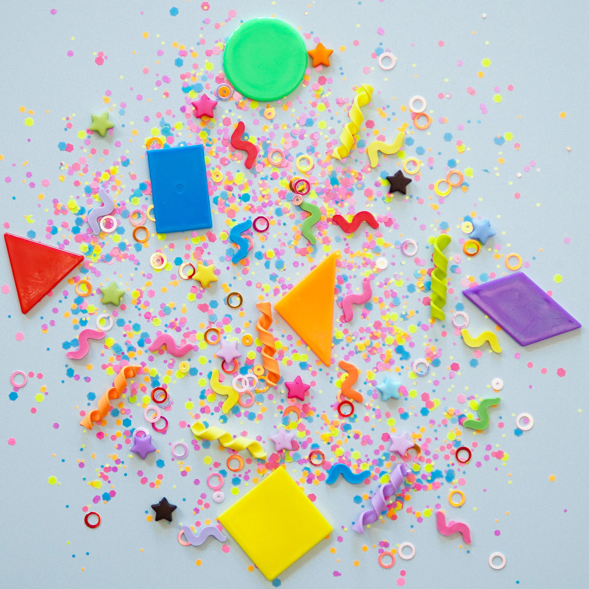 Colorful geometric shapes and confetti on a light blue background