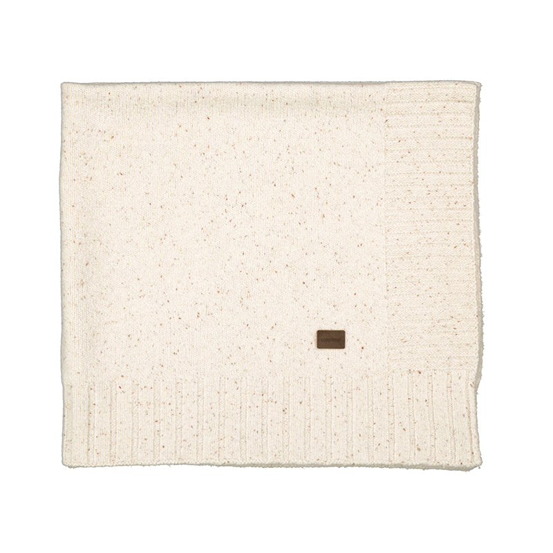 An off-white knit blanket with subtle brown speckles, featuring a ribbed border and a small brown square label near the bottom center, shown on a plain white background.