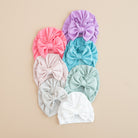Set of colorful headbands with large bows on a beige background