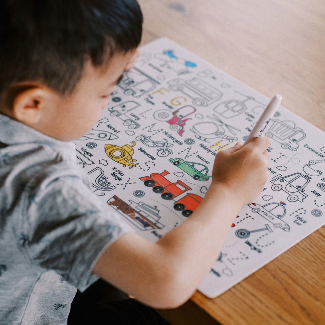 Child coloring on a paper with various illustrations