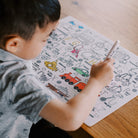 Child coloring on a paper with various illustrations