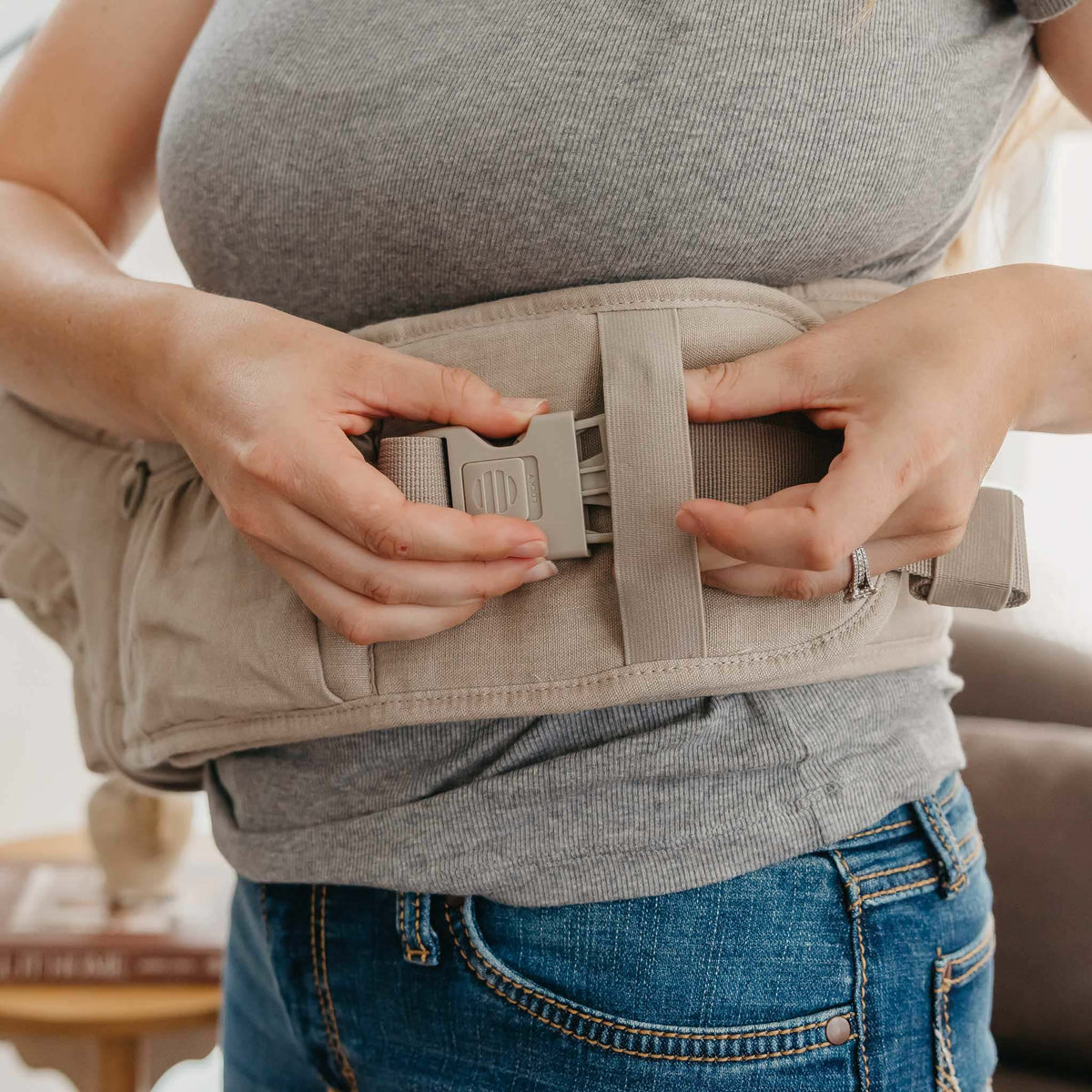 Person adjusting a beige belly band around their waist.