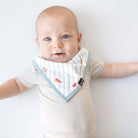Baby wearing a striped bib with a plain background