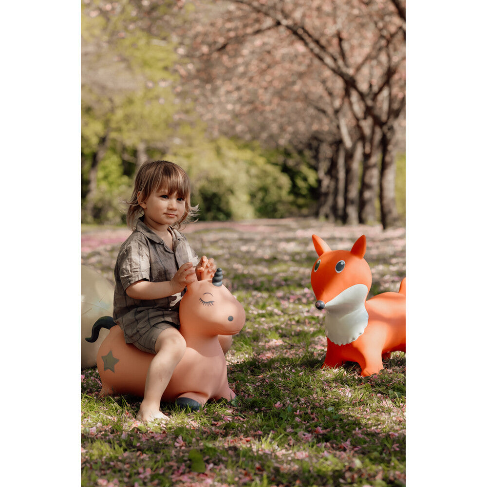 Child playing with inflatable animal toys in a park setting