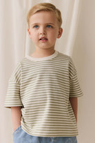Young child wearing a striped shirt against a neutral background