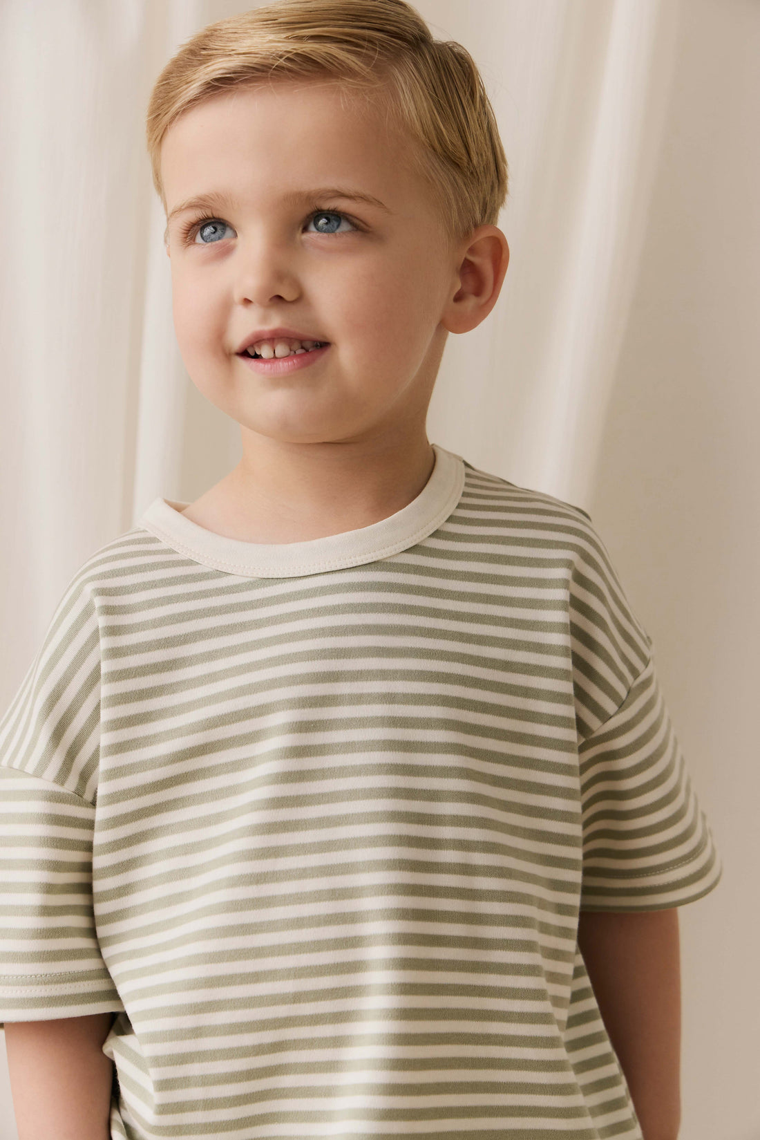 Young boy wearing a striped shirt against a plain background