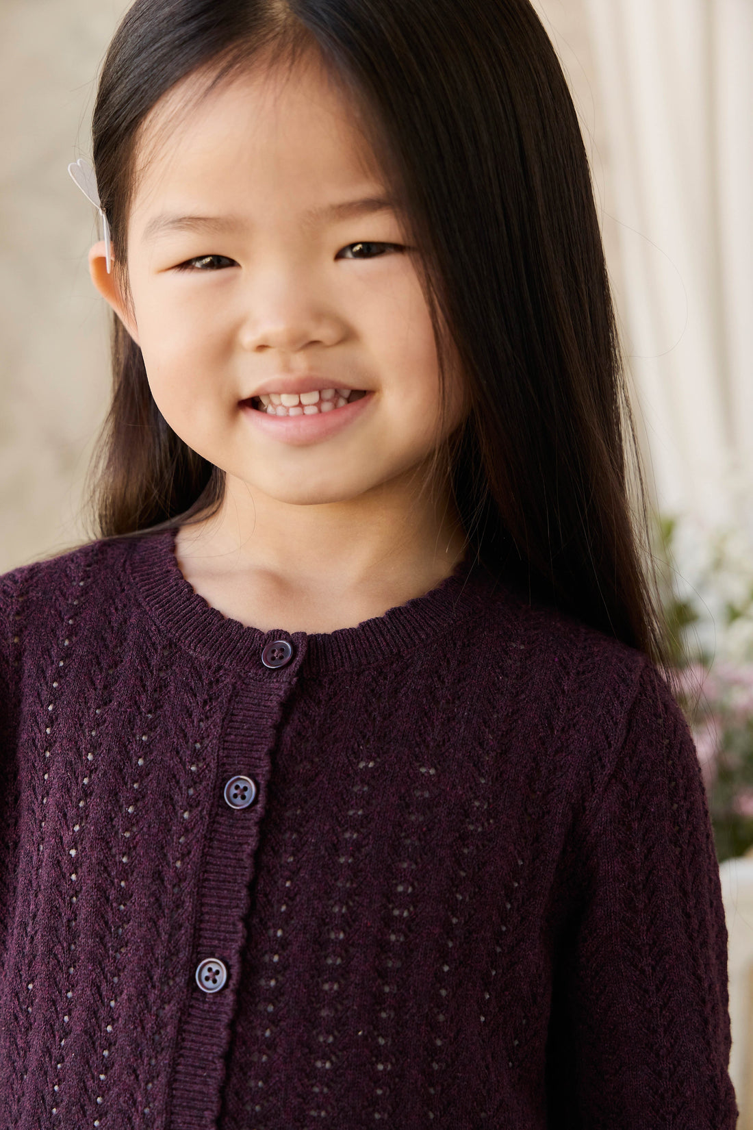 Young girl wearing a purple sweater with a blurred background