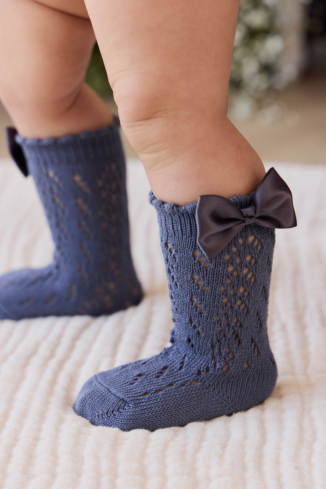 Blue baby socks with a bow on a white surface