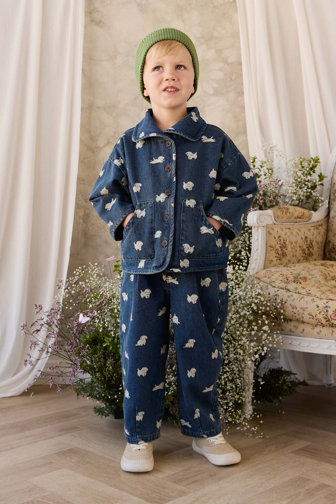 Child wearing a denim outfit with white patterns in a decorated room.