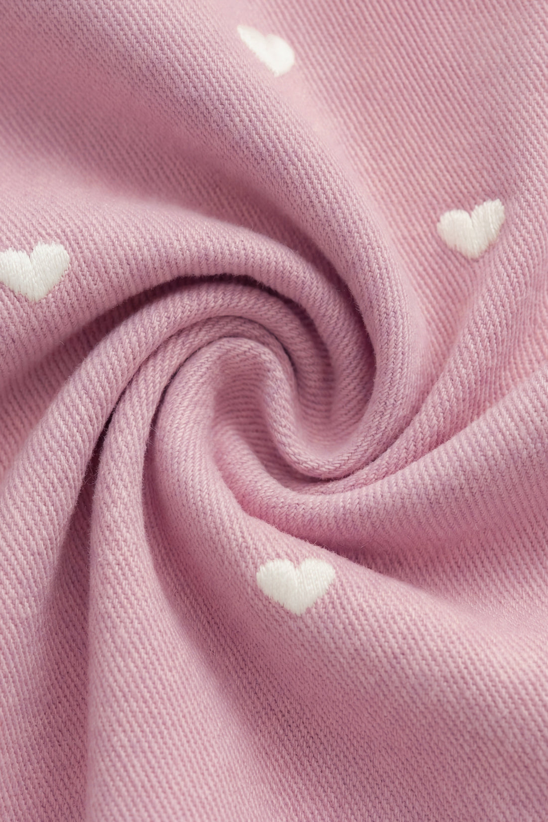 Pink fabric with heart shapes, close-up view