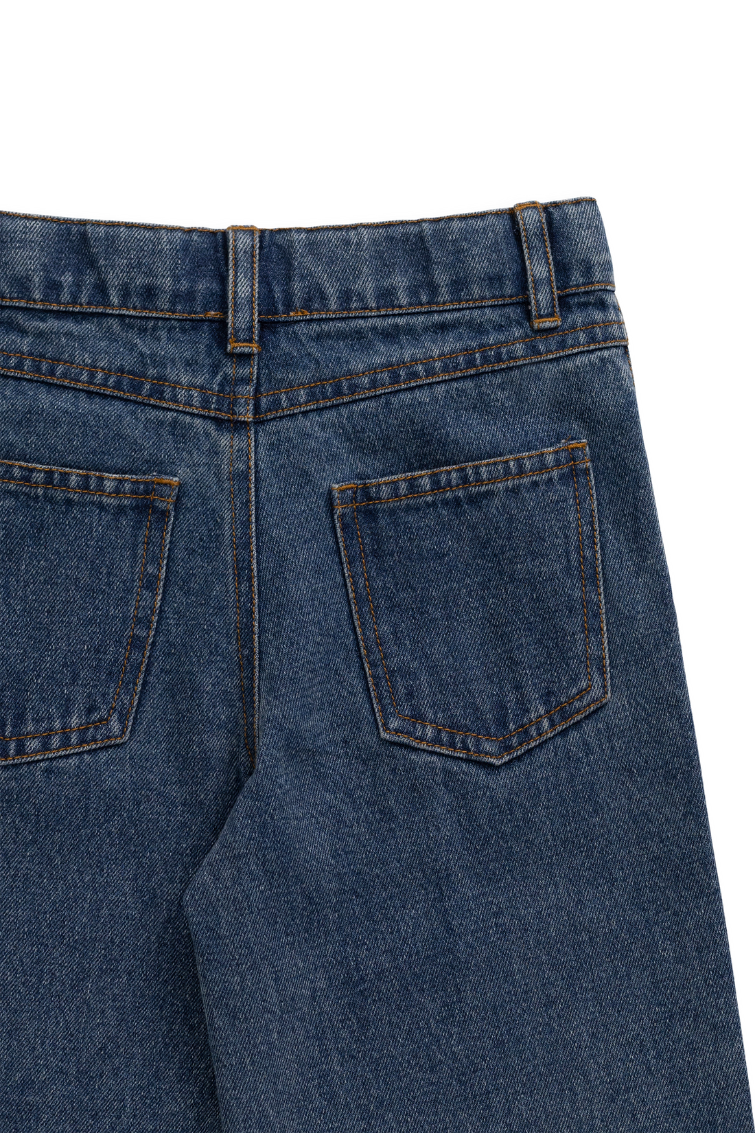 Close-up of the back waistband and pockets of dark blue denim jeans on a white background.