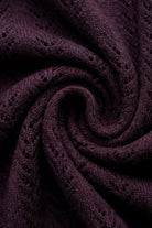A close-up of a dark plum purple knit fabric with a textured openwork pattern, arranged in a spiral swirl.