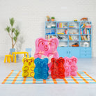 Colorful gummy bear-shaped lamps on a checkered blanket with a room background