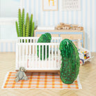 Nursery room with crib, toys, and decorative elements on a light blue striped wall.