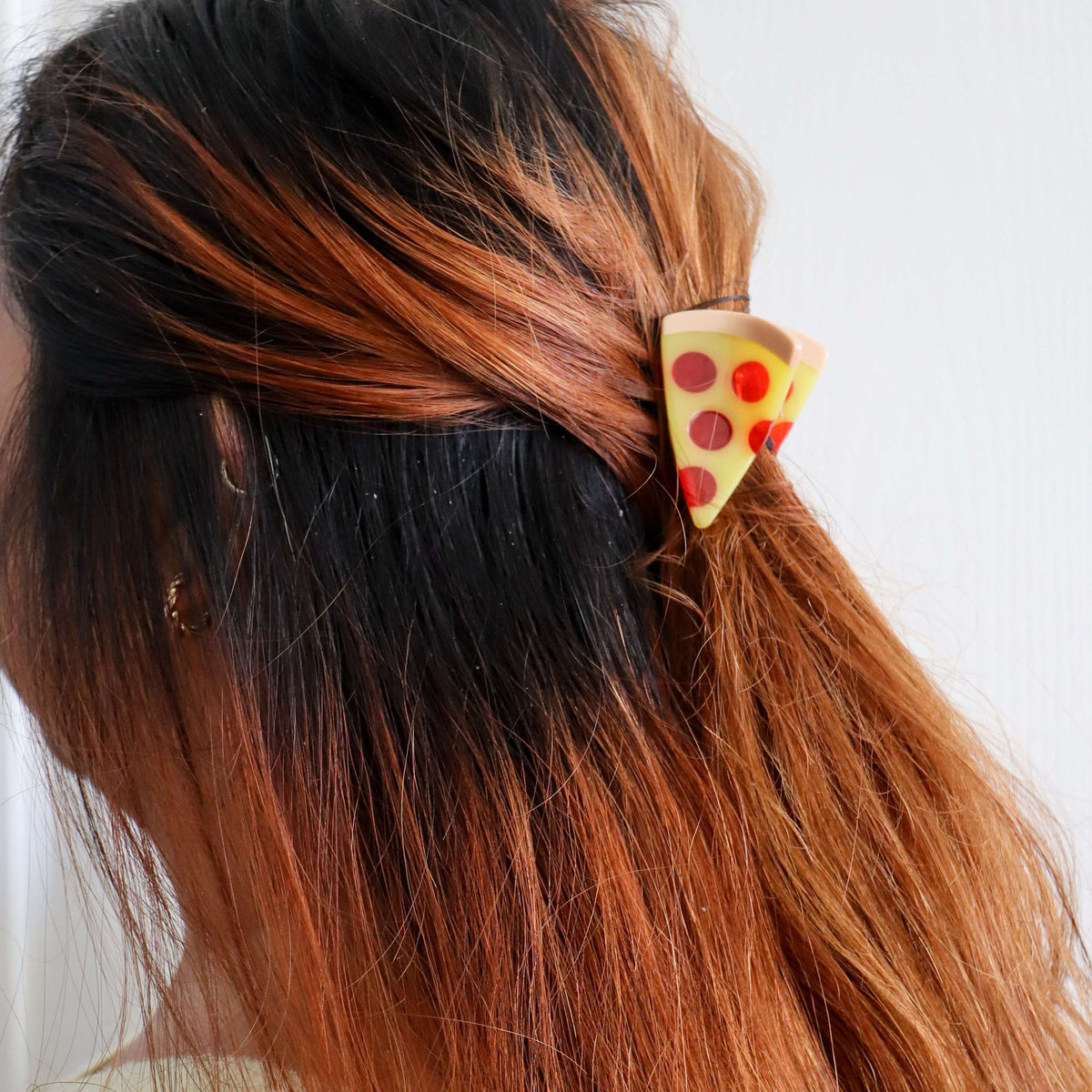 Person with pizza-shaped hair clip in their hair