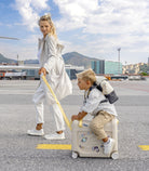 Woman and child with a suitcase at an airport