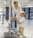 Woman and child using a hand sanitizer station in a public building