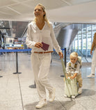 Woman and child walking through an airport with a suitcase