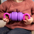 Child holding a purple and pink textured object