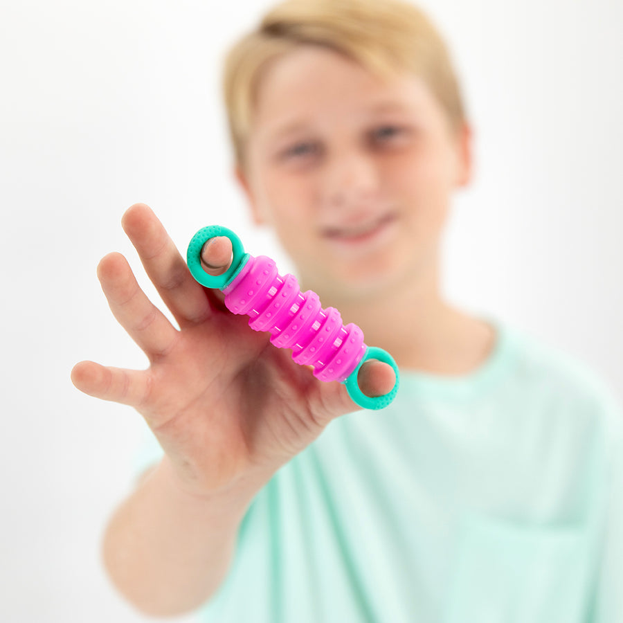 Person holding a pink and green resistance band with a blurred background