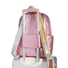 Pink backpack with a rolling suitcase attachment on a white background