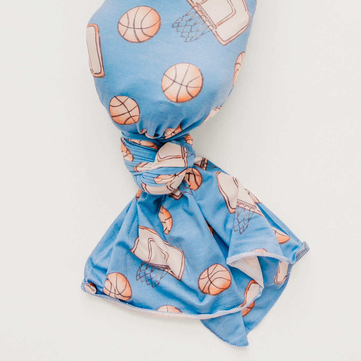 Blue knotted headband with sports-themed pattern on a white background
