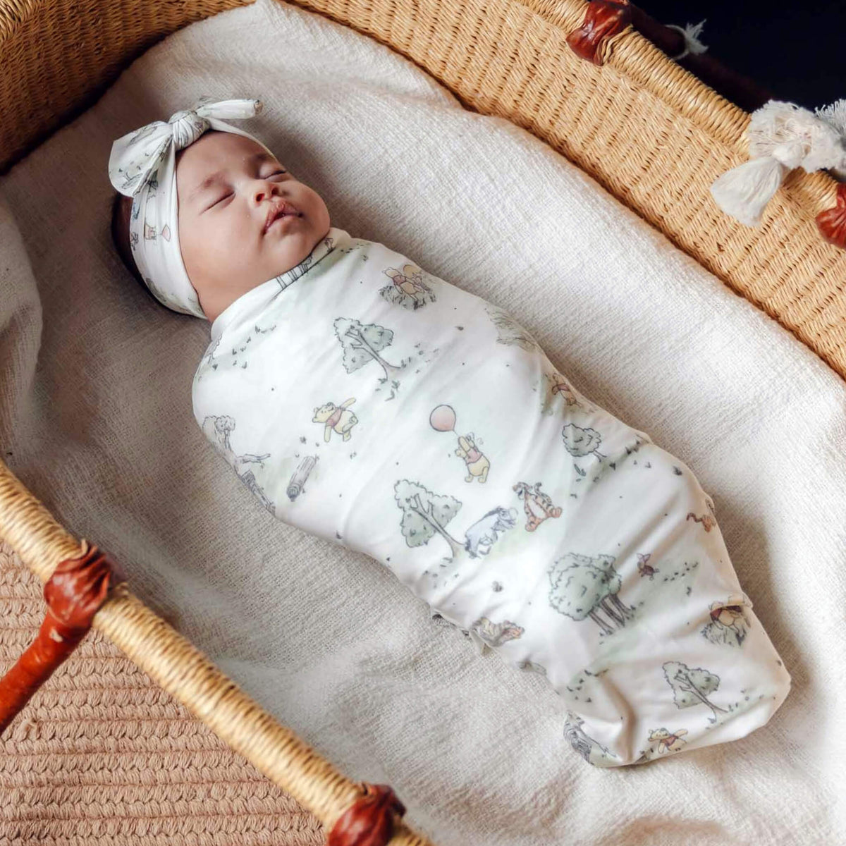 Newborn baby swaddled in a crib with a patterned blanket