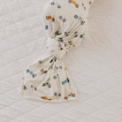 Baby headband with car pattern on a white quilted surface