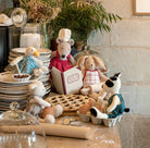 Set of toy animals in a kitchen scene with plates, eggs, and a pie.