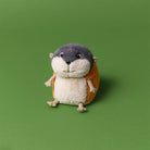 Plush toy otter on a green background