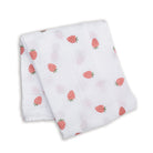 Folded white fabric with red strawberry pattern on a white background