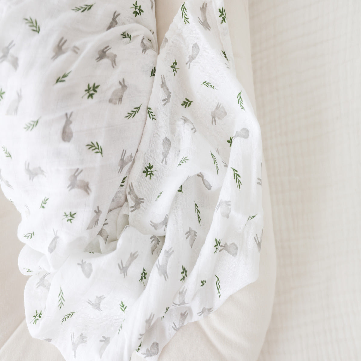 White fabric with green leaf pattern on a white background