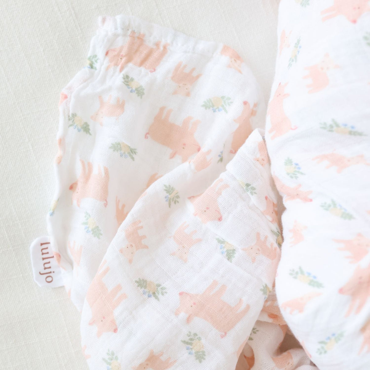 Baby blanket with pink and green pattern on a light background