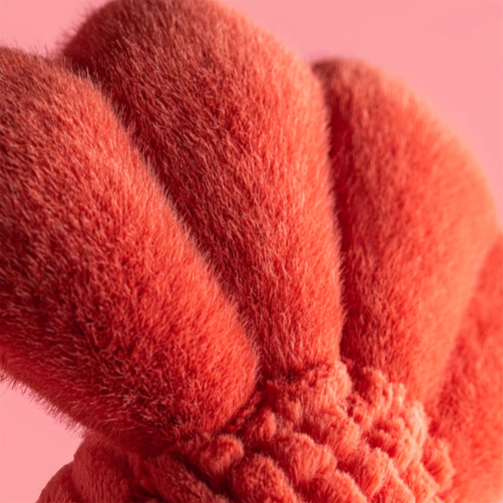 Close-up of a fluffy red object against a pink background